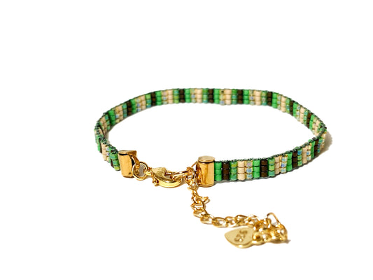 Green and earth-tone handwoven peyote bracelet with Miyuki seed beads, geometric design, and 18k gold-plated brass clasp, adjustable size.